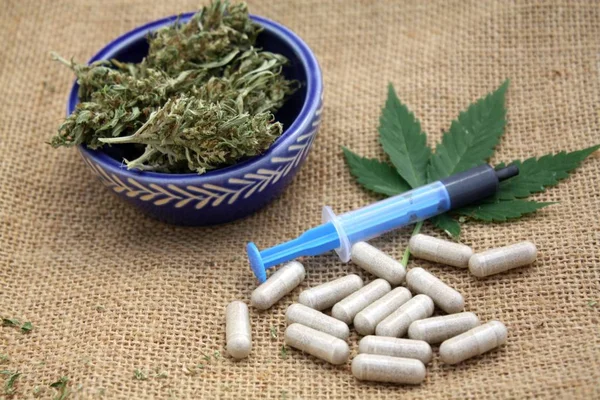 Хешування олії Фенікс сльози медицини в маленькому шприці з сухими марихуановими бруньками і листям конопель . — стокове фото