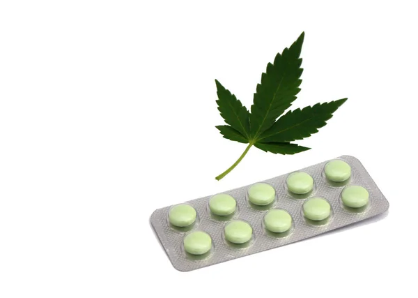 Marihuana leki konopi narkotyków lekarstwo leków lekarstwa pigułki. Zielone stoły i liść ganja na białym tle. — Zdjęcie stockowe