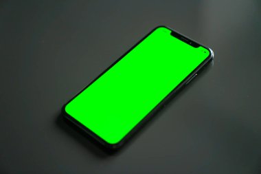 iPhone X, gri bir arka plan üzerinde yeşil ekran