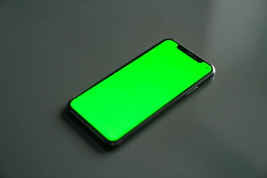 iPhone X, gri bir arka plan üzerinde yeşil ekran
