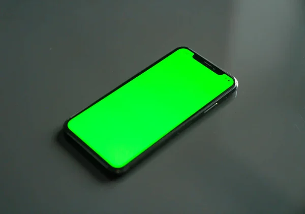 Iphone 灰色背景上的绿色屏幕 — 图库照片
