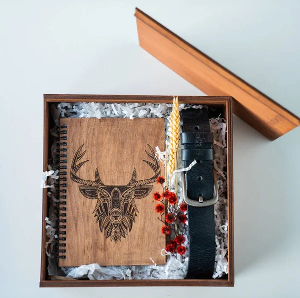 man\'s gift with a notepad made of wood and a belt