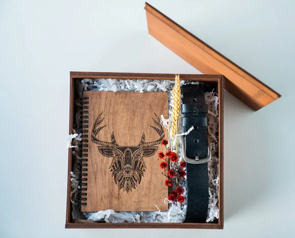 man\'s gift with a notepad made of wood and a belt