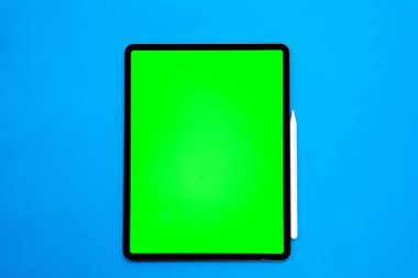 iPad ve iPhone, bir kalem ile mavi arka planda yeni tablet, ve yeşil ekran üst görünümü