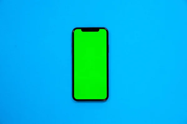 Telefoon Smartphone Groen Scherm Blauwe Achtergrond Bovenaanzicht — Stockfoto