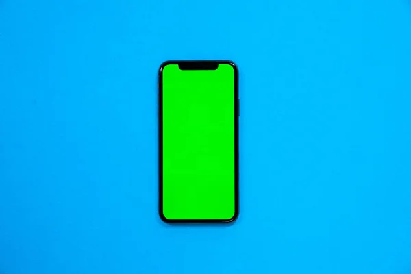 Telefon smartphone, mavi arka plan üst görünümünde yeşil ekran