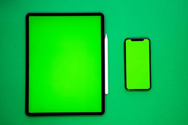 iPad ve iPhone, bir kalem ile yeşil arka planda yeni tablet, ve yeşil ekran üst görünümü