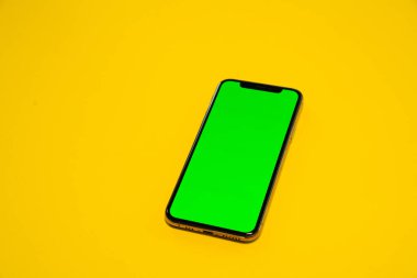 iPhone XS, telefon smartphone, sarı arka planda yeşil ekran