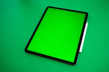 iPad ve iPhone, bir kalem ile yeşil arka planda yeni tablet, ve yeşil ekran üst görünümü