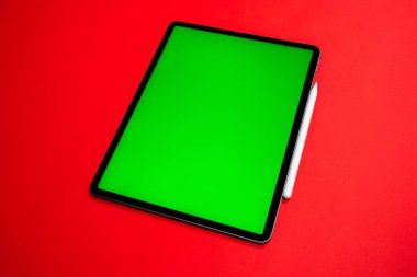 iPad ve iPhone, bir klavye ve kalem ile kırmızı arka planda yeni tablet, ve yeşil ekran üst görünümü