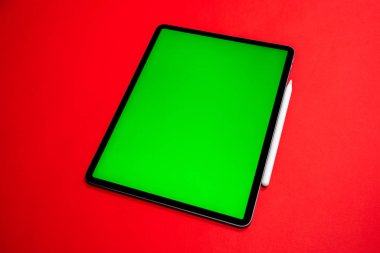 iPad ve iPhone, bir klavye ve kalem ile kırmızı arka planda yeni tablet, ve yeşil ekran üst görünümü