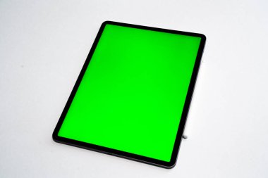 iPad ve iPhone, beyaz arka planda bir kalem ile yeni tablet ve yeşil ekran üst görünümü