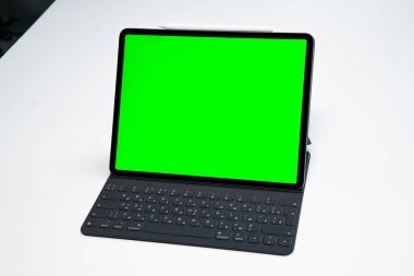 iPad ve iPhone, beyaz arka planda bir kalem ile yeni tablet ve yeşil ekran üst görünümü