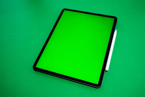 iPad ve iPhone, bir kalem ile yeşil arka planda yeni tablet, ve yeşil ekran üst görünümü