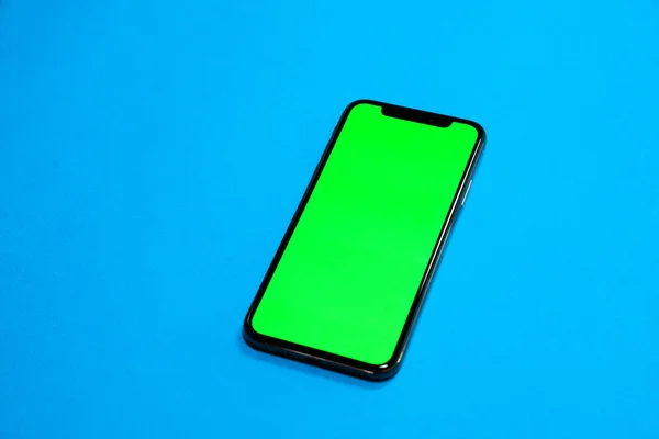 Telefon smartphone, mavi arka plan üst görünümünde yeşil ekran