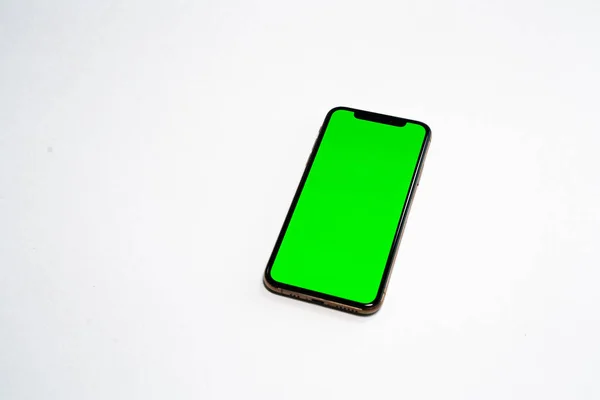 Beyaz arka plan üstünde telefon smartphone, yeşil perde