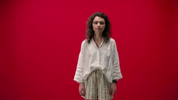 Σγουρά Κορίτσι Χαίρεται Και Δείχνει Δροσερό Ένα Κόκκινο Φόντο Επιτυχής — Αρχείο Βίντεο