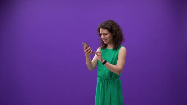 Menina Encaracolado Joga Jogos Iphone 11Pro Uma Mão Fundo Roxo — Vídeo de Stock