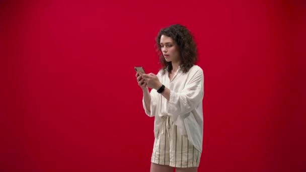 Kudrnaté Dívka Hraje Hry Iphone 11Pro Ruce Červeném Pozadí — Stock video