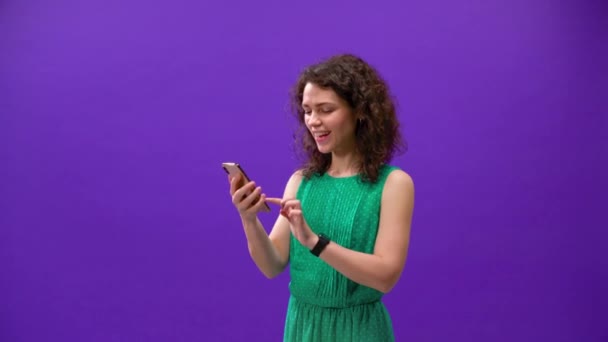 Curly Girl Грає Ігри Iphone 11Pro Руці Фіолетовому Фоні — стокове відео