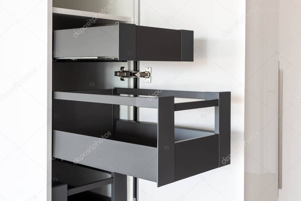 Opened kitchen cabinet with inner drawers inside in white and grey colors