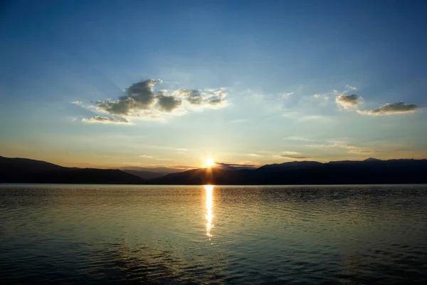 Panoramik manzaralı sakin deniz su üzerinde altın günbatımı