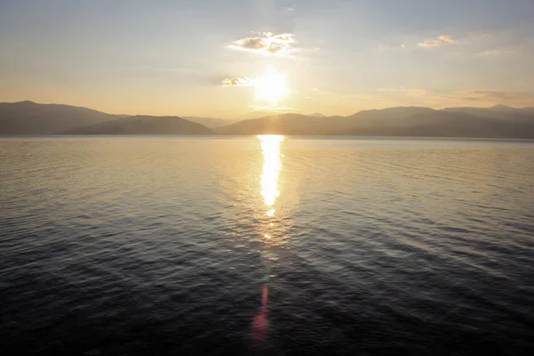 Panoramik manzaralı sakin deniz su üzerinde altın günbatımı