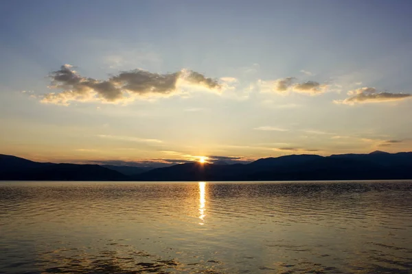 Panoramik manzaralı sakin deniz su üzerinde altın günbatımı