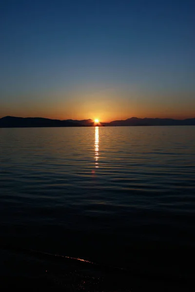 Panoramik manzaralı sakin deniz su üzerinde altın günbatımı
