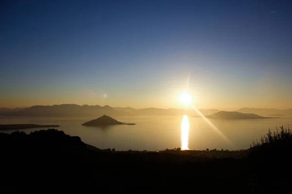Panoramik manzaralı sakin deniz su üzerinde altın günbatımı
