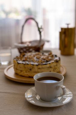 Masada bir fincan kahveyle kutlama peynirli keki. Paskalya zamanı.