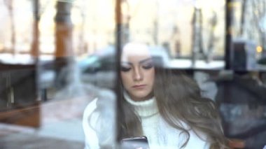 Cafe Onu Smartphone Kullanarak 4k Güzel Esmer Kız. Pencereden Fro'ya Bak