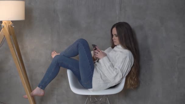 Fille Dans Une Chaise Regardant Téléphone — Video