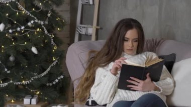 Arka Planda Xmas Ağacı ile Güzel Seksi Kadın Bir Kitap Okuma