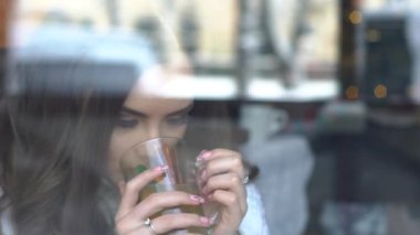 Kız kafede çay içiyor. Pencereden Görüntüle