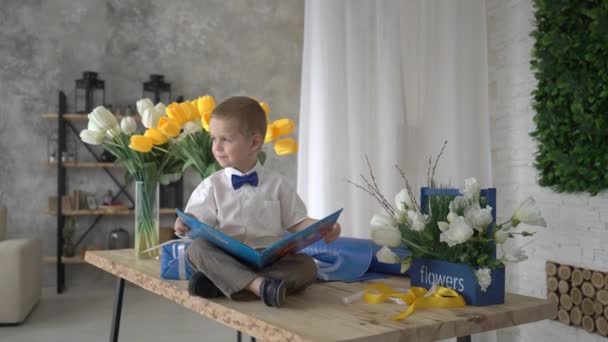 Boy Leest Boek Kijkt Naar Venster Home — Stockvideo