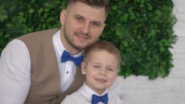 Çekici kahverengi gözlü baba ve küçük adam kameraya bakıyor