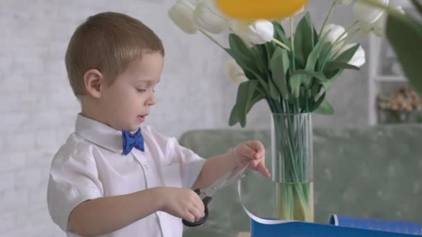 白いリボンで包まれたギフトボックスを飾る少年 — ストック動画