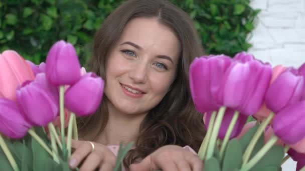 Aantrekkelijke Jonge Vrouw Die Achter Tulpen Kijkt — Stockvideo