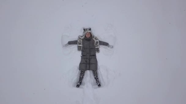 Kobieta Making Snow Angel Leżącego Czystej Białej Śniegu — Wideo stockowe