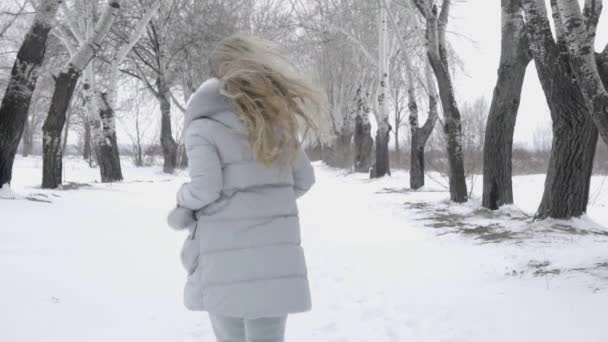 女孩在寒冷的冬天穿过雪 — 图库视频影像