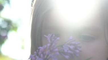 Kız leylak kokusu tadını çıkarıyor. Çiçekler koku nefes