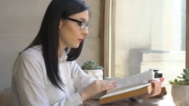 Kafe 'de ders kitabı okuyan genç bir kız.