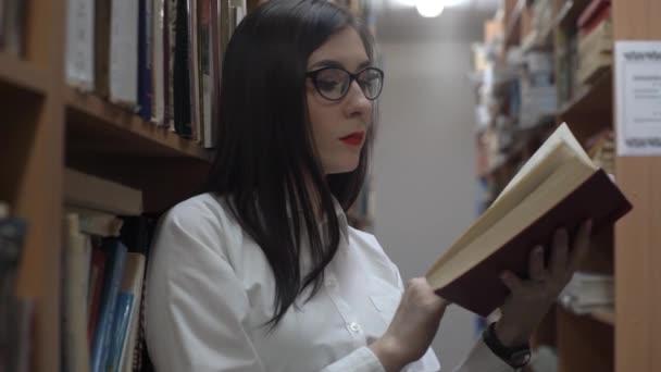 Όμορφη Νεαρή Καυκάσιος Γυναίκα Ανάγνωση Βιβλιοθήκη Μεταξύ Των Στοίβες — Αρχείο Βίντεο