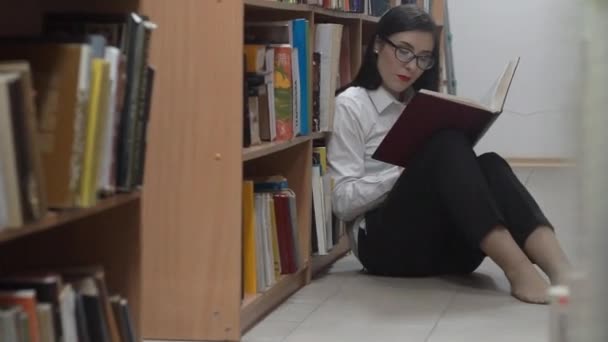 Jovem Estudante Lendo Livro Biblioteca — Vídeo de Stock