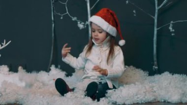 Gerçek Zamanlı Noel Baba Şapkasındaki Kız KarLarı Fırlatıyor. Yapay Kar