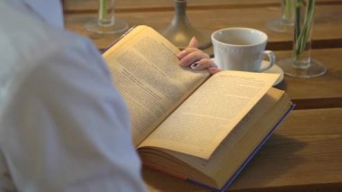 kadın bir kitap okur, bir sayfa döndürülür yakın çekim