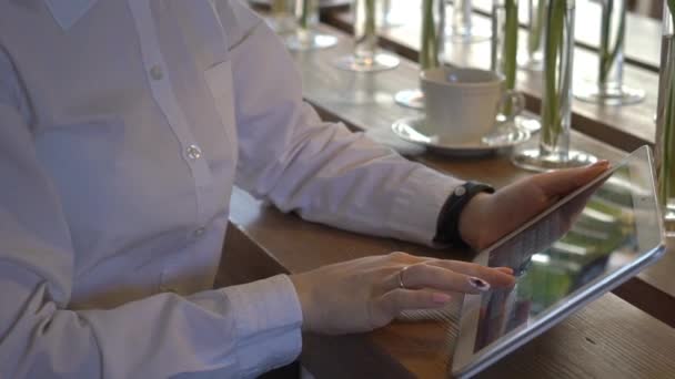 漂亮的女孩坐在咖啡馆的桌子 并使用平板电脑 — 图库视频影像