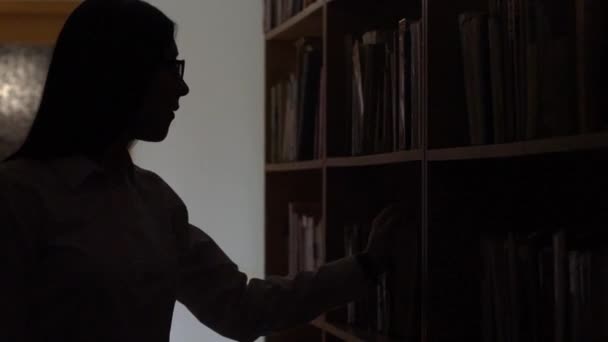 Silhouette Einer Frau Die Ein Buch Der Bibliothek Sucht — Stockvideo