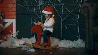 4k Kız Noel Ağacı yakınında bir Oyuncak At Sürme
